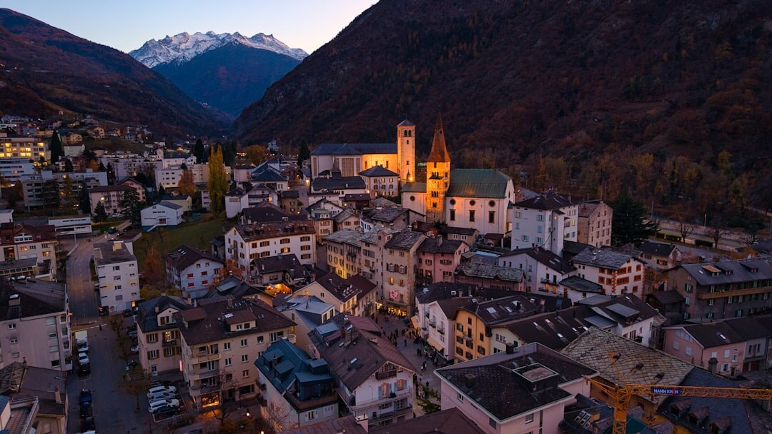 Swiss alpine village illuminated at dusk with snow-capped mountains